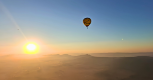Hot air balloon flying above the Magalies River Valley during a winter sunrise in South Africa