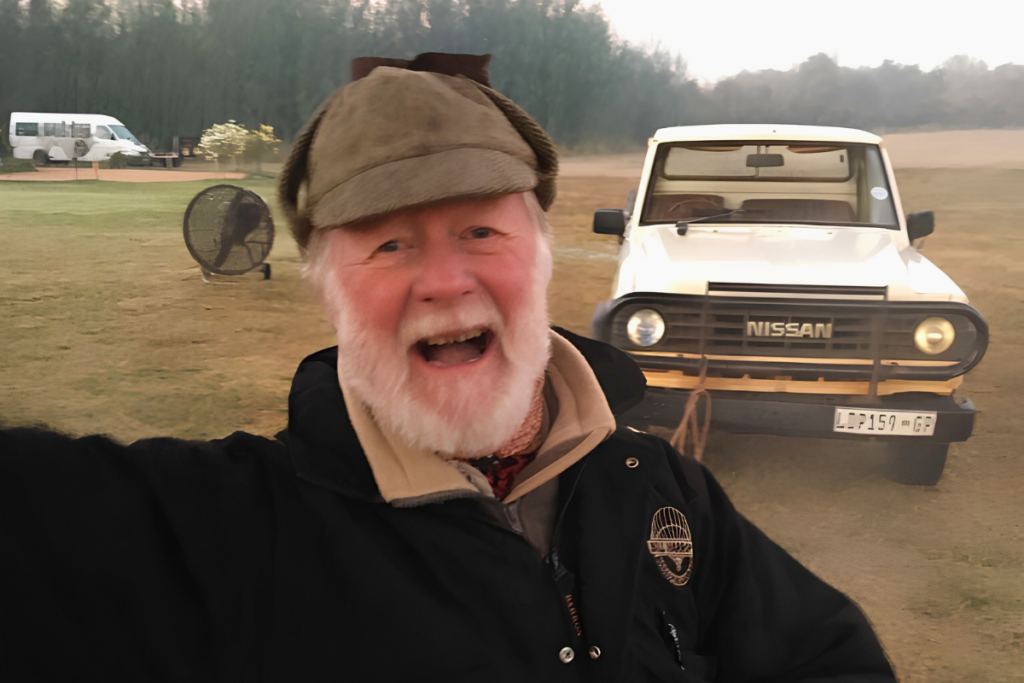 Bill Harrop at the balloon safari launch site with a ground crew vehicle behind him