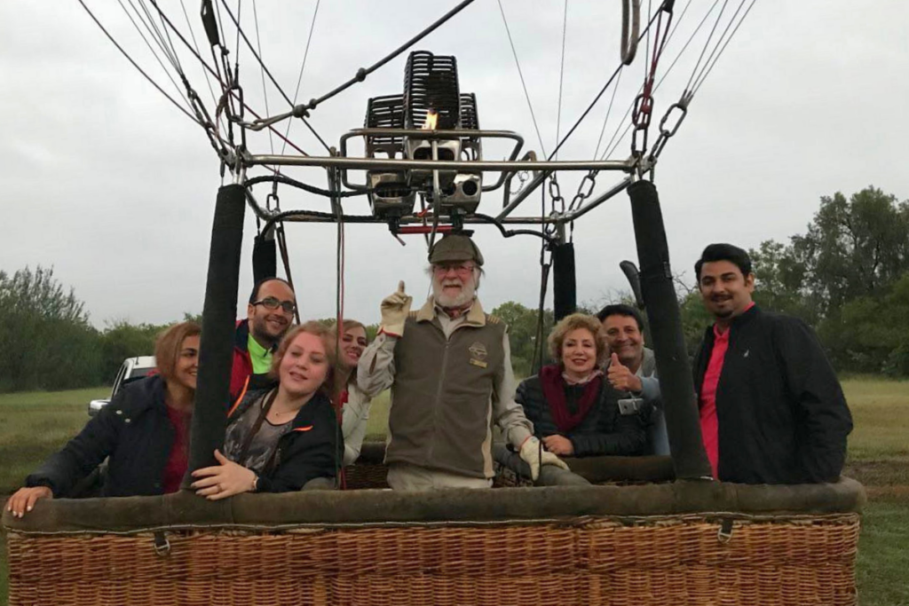 Bill Harrop standing with passengers inside a hot air balloon basket