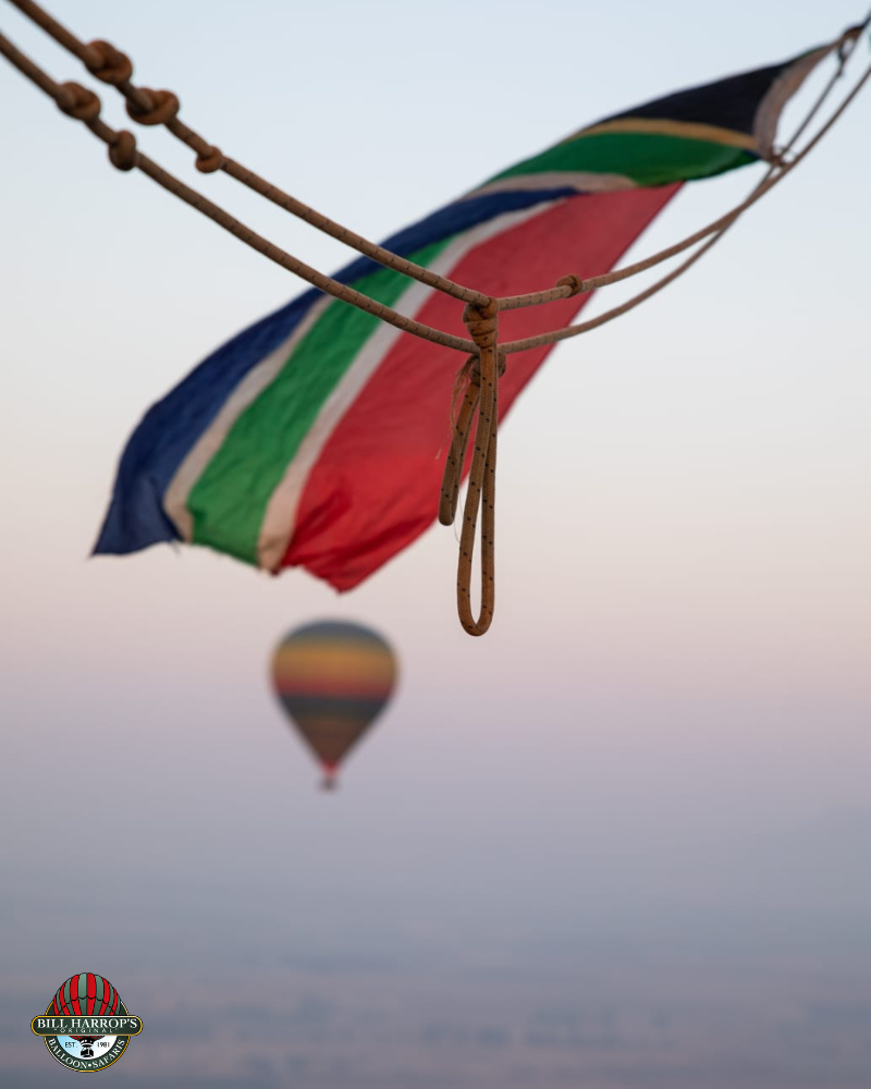 South African flag flying from a hot air balloon with another balloon in the distance